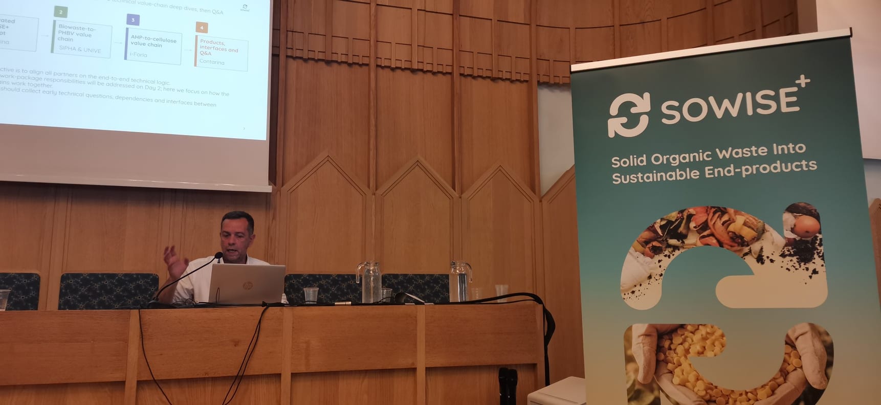 A partner presenting the SOWISE+ value chains at the Kick-off Meeting, beside the SOWISE+ roll-up banner